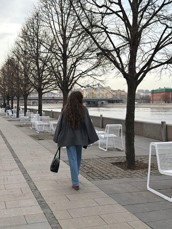 Woman walks past spring flowers on Moscow walkway