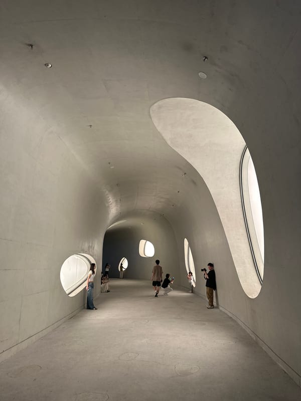 Visitor documents curved architecture at Shenzhen Art Museum