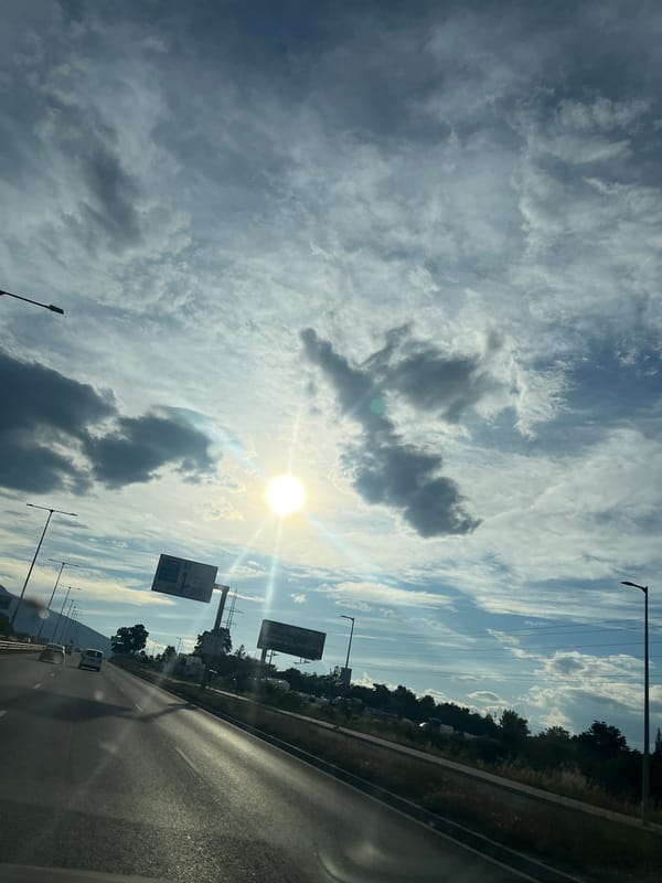 Highway drive under a dramatic, sun-breaking-through-clouds sky