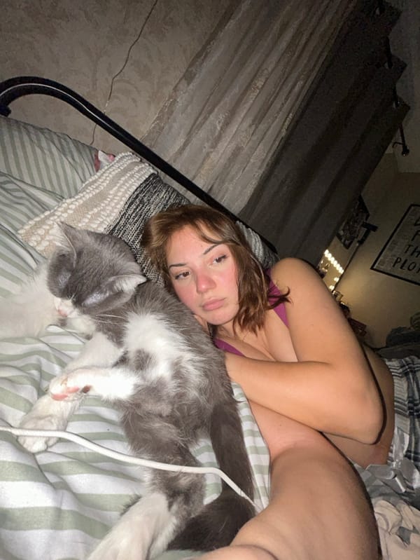 Woman spends evening relaxing in bedroom with cat in France