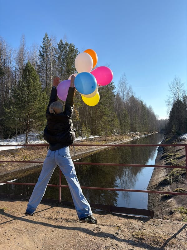 Woman poses with balloons, umbrella at Chernushka waterfall