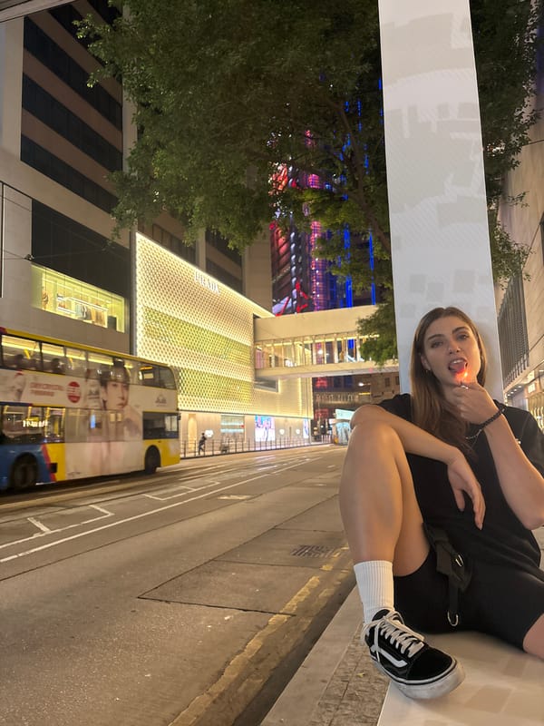 Woman sits on ledge holding lighter in Hong Kong