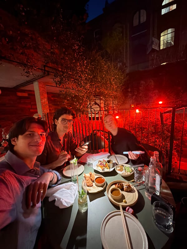 Late-night outdoor dining in London, red-lit rooftop setting