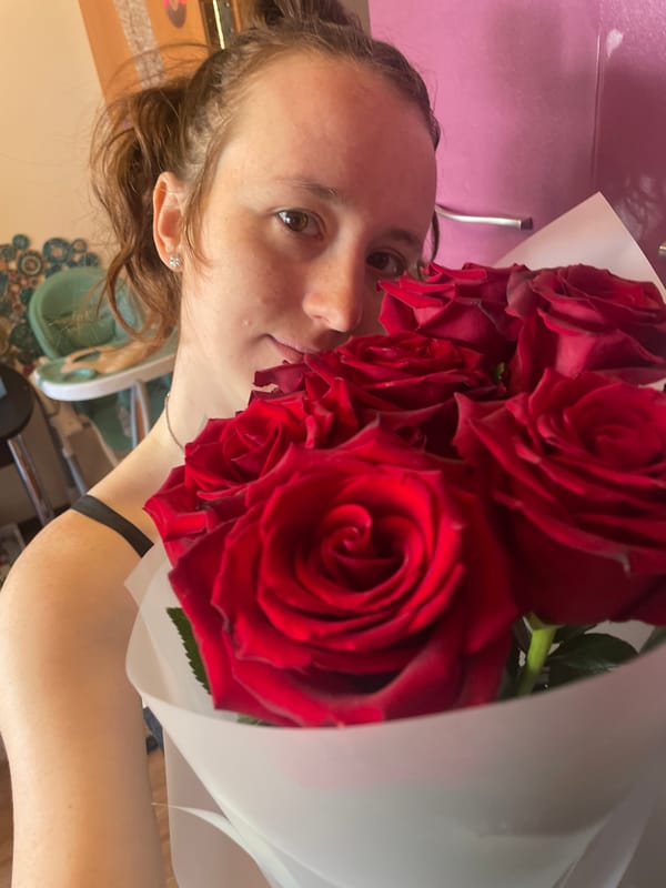 Woman photographed with roses and cat in tender moments