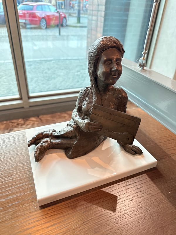 Bronze reading child sculpture observed on table in Wrocław