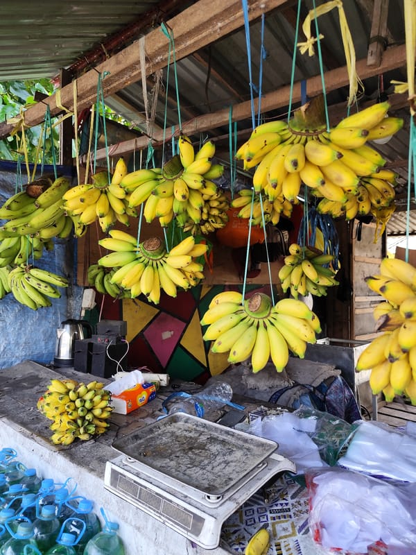 Open-air stall serving food with bananas and bottled drinks