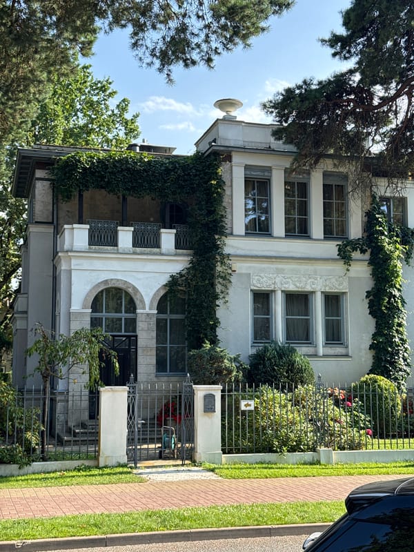 Ivy-covered white house behind iron gate in Jūrmala