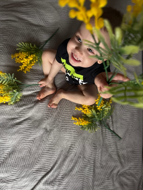 Toddler sits on blanket with yellow flowers in Fedorino