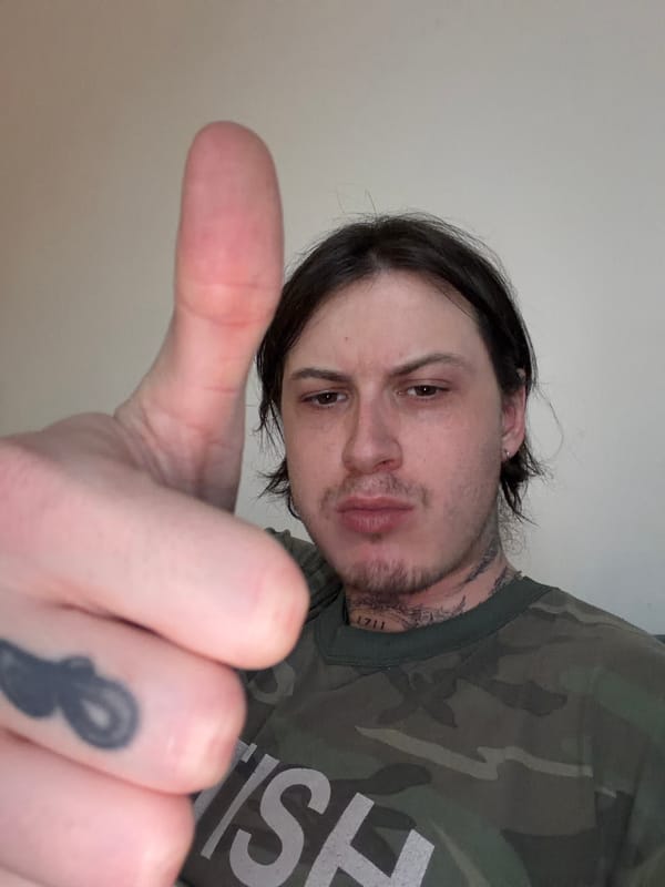 Person gives thumbs-up gesture in London