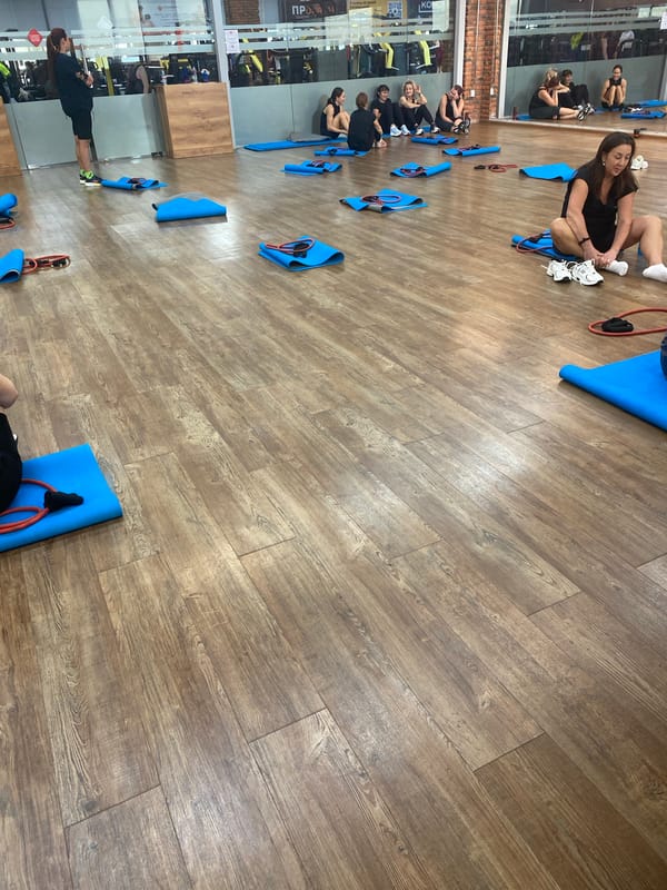 Women participate in fitness class at indoor gym