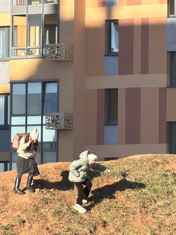 Two people stand near modern building in Izhevsk