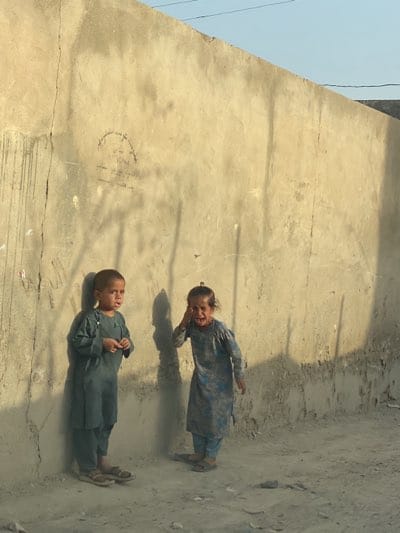 Children play in dusty Kandahar street scene