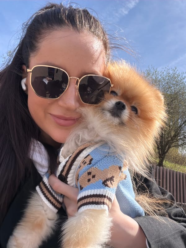 Woman walks Pomeranian through Khimki neighborhoods on sunny morning