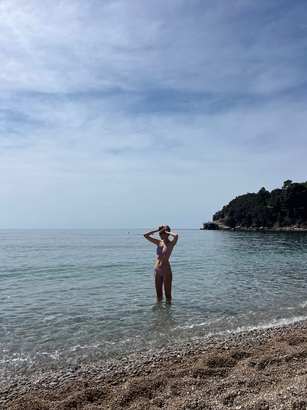 Woman in pink swimsuit enjoys morning waters in Budva