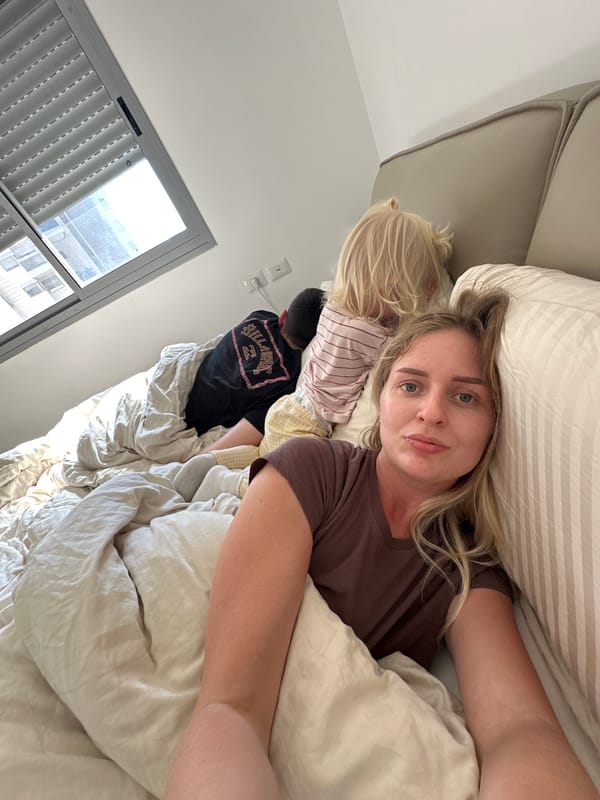Woman rests on bed in Petah Tikva with companion
