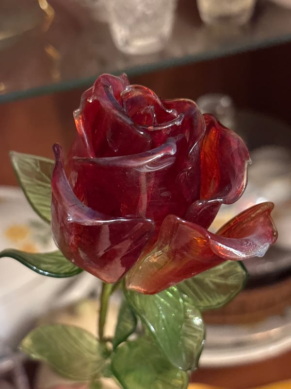 Glass rose, crocheted doily, and church miniature up close
