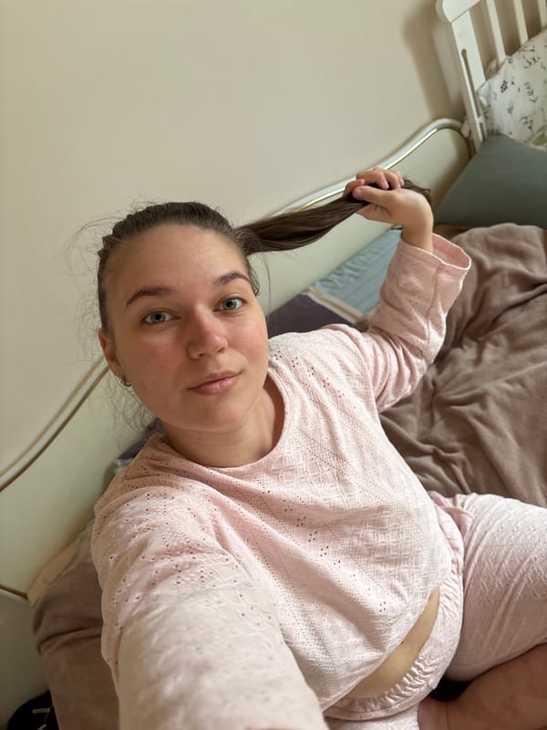 Woman rests in pajamas on bed in Chaikovsky apartment