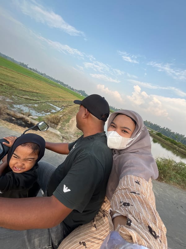 Families riding motorcycles through Kruengmate, Indonesia