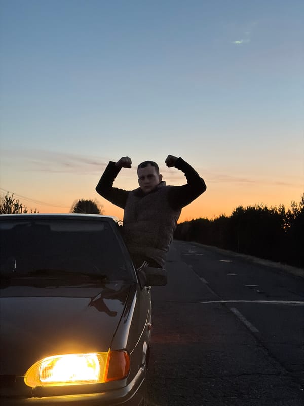 Young man poses from car window in Kharnavy, Russia
