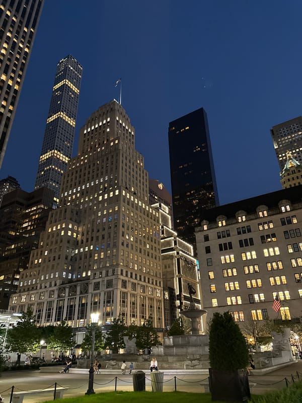 Midtown Manhattan glows at night from a public plaza