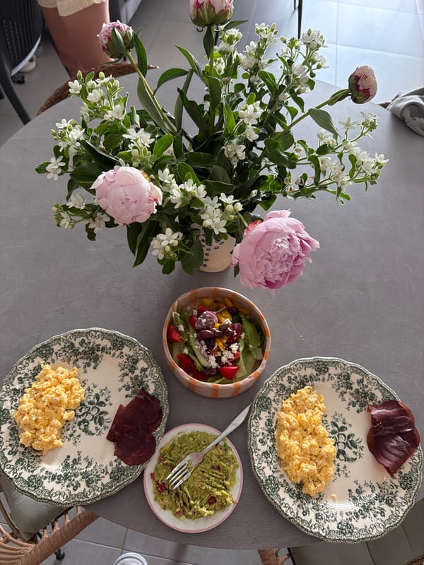 Morning breakfast table set with flowers and scrambled eggs
