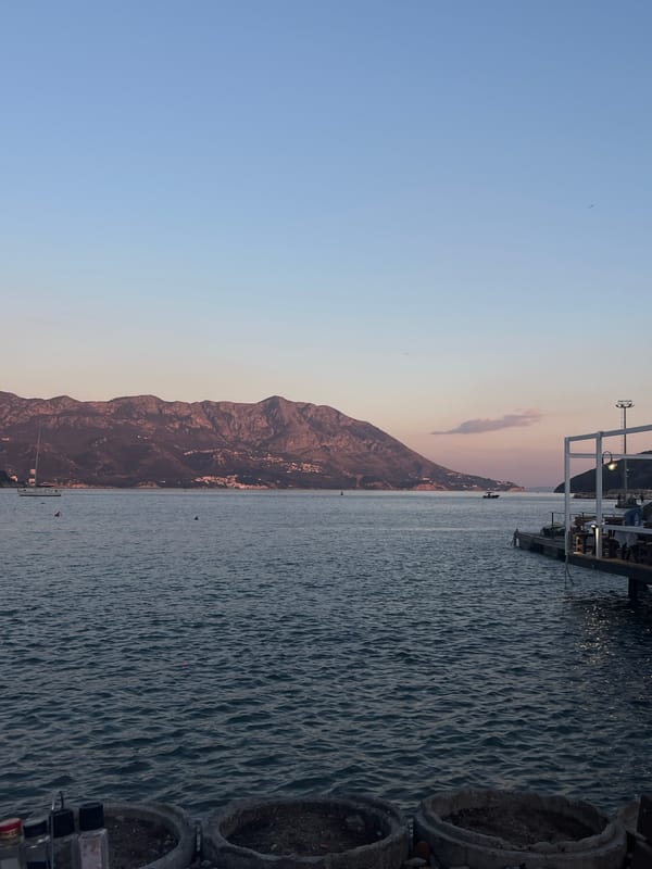 Seaside dining pier captures sunset colors in Budva, Montenegro
