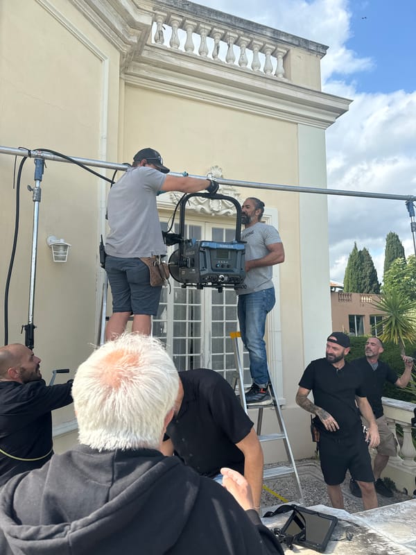 Film crew works at European-style villa with ornate entrance