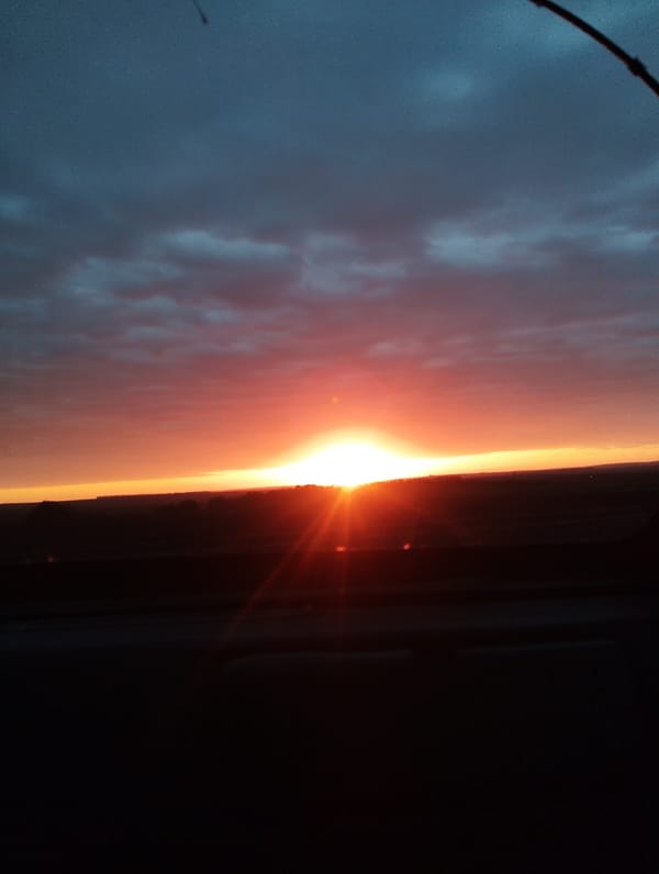 Vibrant sunset captured over silhouetted landscape
