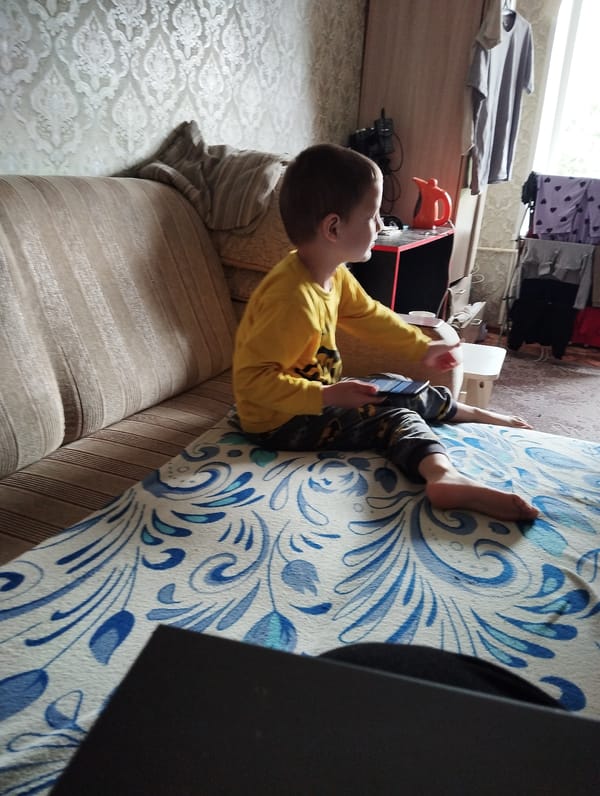 Handheld gaming on a striped sofa in Kingisepp