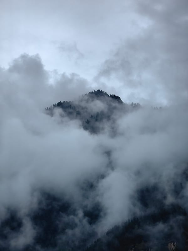 Cloudy day in Manali — peaks, fog, and mountain road traffic