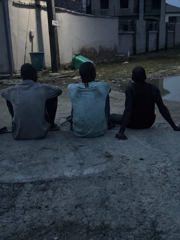Three males rest outdoors in Iranla, Nigeria