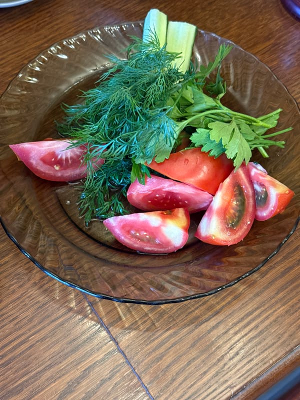 A relaxed home meal with fresh produce, sardines, and red wine