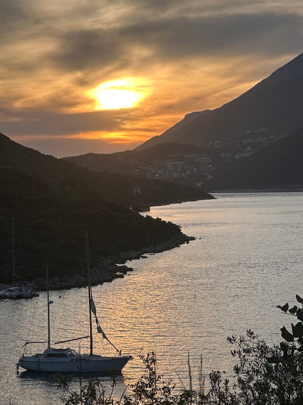 Sunset observed at Kaş harbor with sailboats and mountain backdrop