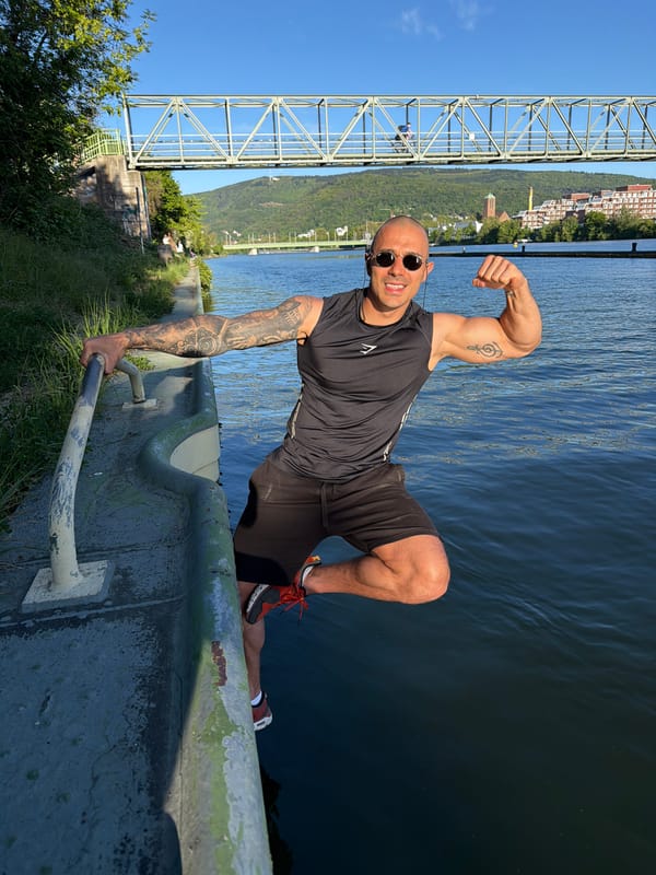 Man poses for riverside photo in Heidelberg
