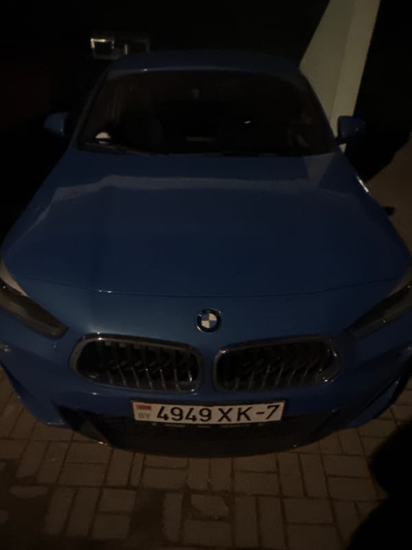 Cars parked on brick pavement during Minsk evening