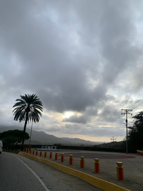 Evening traffic flows through La Asuncion under cloudy skies