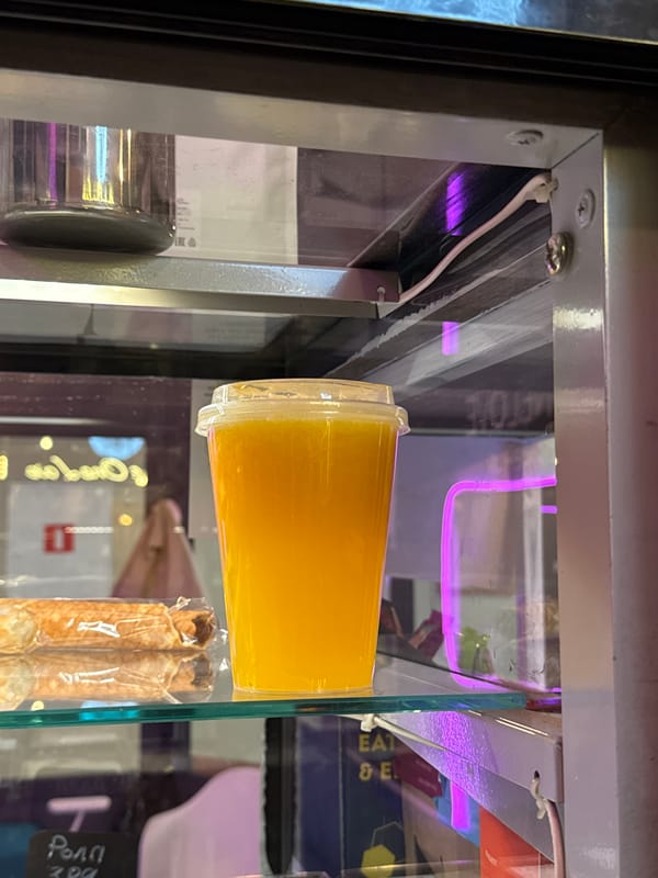 Orange drink and a snack on a glass shelf in Moscow