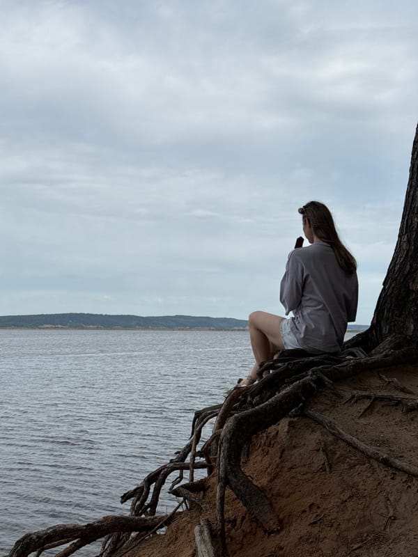 Woman enjoys morning ice cream by water in Chaikovsky