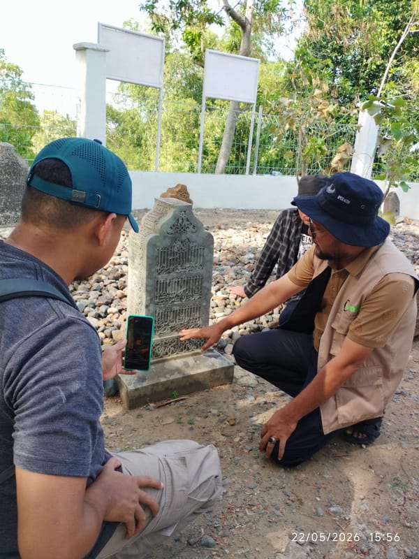 Men photograph Arabic headstone in Ulee Tutue, Indonesia