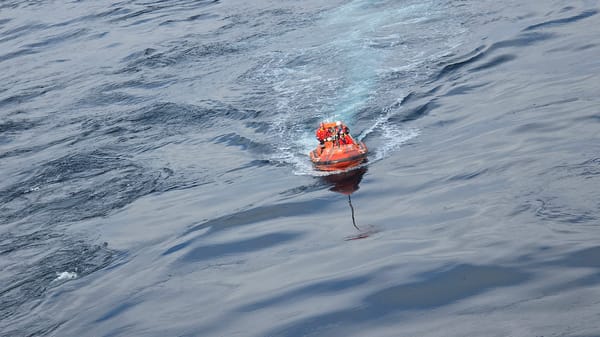 Orange rescue boat with crew operates in North Sea waters