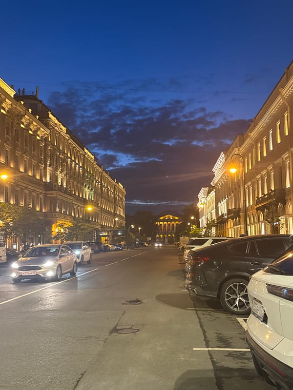 Wet Saint Petersburg street at night, grand architecture under streetlights