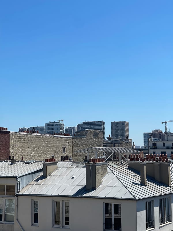 Paris rooftops under a clear blue sky