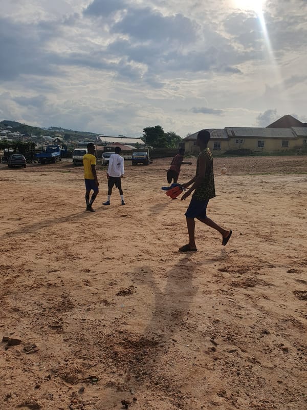 Children play soccer on dusty fields in Lokoja, Nigeria