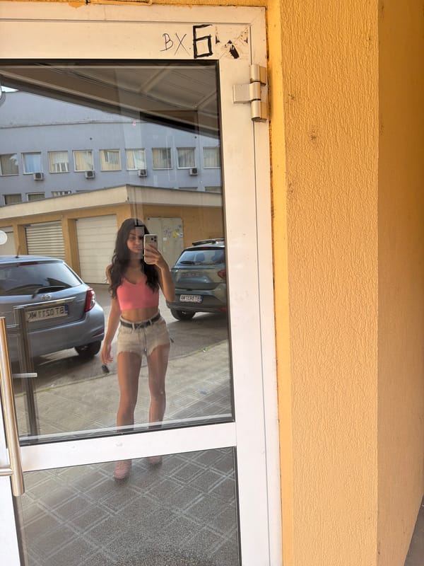Woman takes mirror selfie at glass door in Veliko Tarnovo