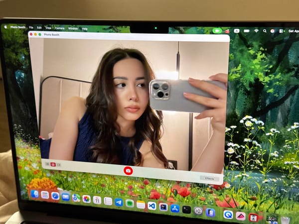 Woman takes selfie using smartphone and laptop Photo Booth app
