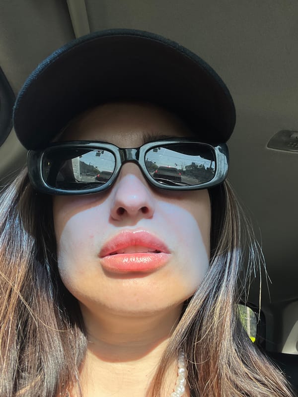 Person in sunglasses observed inside vehicle in urban setting