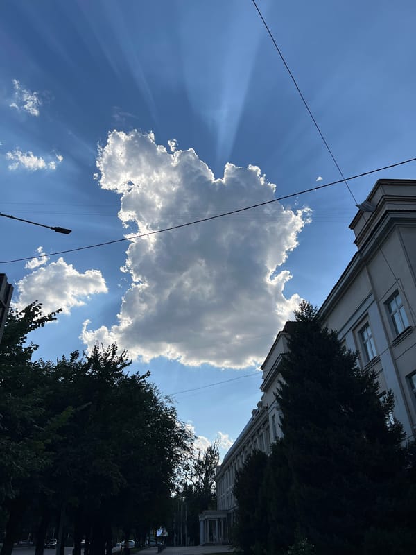 Sunrays pierce through cumulus clouds above Almaty