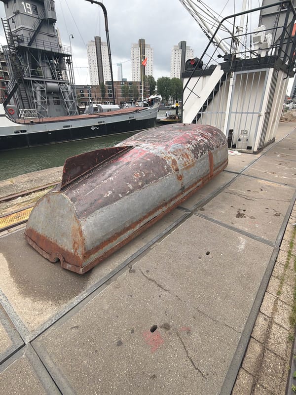 Tourist documents Rotterdam's historic harbor landmarks during overcast afternoon