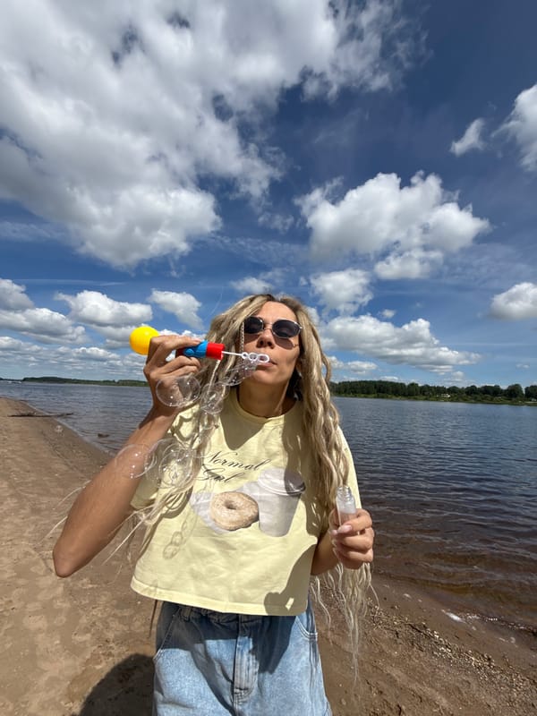 Person blows bubbles by water in Rusanovo, Russia