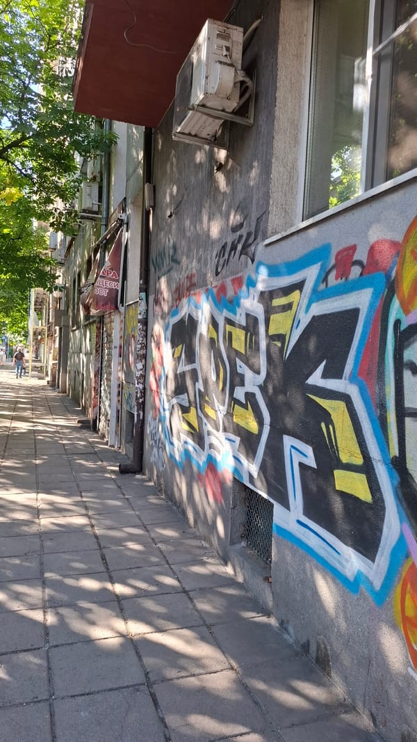 Sofia street walls thick with graffiti on a summer afternoon